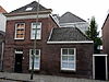 In schoon metselwerk opgetrokken pand met verdieping onder met blauwe Hollandse pannen gedekt zadeldak