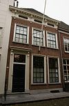 Huis onder schilddak en met lijstgevel waarop gepleisterde attiek