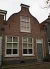 Huis onder zadeldak en met ingezwenkte halsgevel