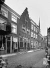 Straatbeeld met winkel en woonhuizen, trapgevel in het midden - Geertruidenberg - 20076040 - RCE -  Huis Aan De Markt: Straatbeeld met winkel en woonhuizen, trapgevel in het midden 