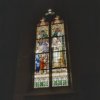 Interieur glas-in-lood raam met opschrift: De opdracht van Maria in de Tempel