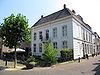 Huis, met schilddak en grijsgepleisterde lijstgevel, deuromlijsting