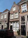 Huis met in- en uitgezwenkte topgevel, beganegronds samengetrokken met de winkel van het vorige huis ('De Bazar')