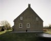 Overzicht van de westgevel met sierankers van de boerderij
