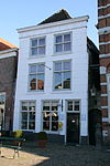 Heusden - Vismarkt 5 - Woonhuis.JPG -  Huis met gebosseerd gepleisterde lijstgevel, schilddak met rode pannen belegd. 