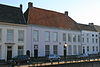 Heusden - Stadshaven 21 - Woonhuis.JPG -  Huis onder dwars schilddak met rode pannen en met gebosseerd grijsgepleisterde lijstgevel; ramen met kleine roedeverdeling. 