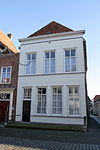 Huis onder schilddak en met gepleisterde lijstgevel, aan de achterzijde, waarbij aansluit gasthuisstraat 12, een topgevel met sierankers