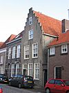 Huis met zadeldak en gecemente topgevel, waarin vensters met schuiframen