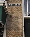 Detail zijgevel Vismarkt, klezoortjes links van de deur, nummerbordje van nummer 14 en straatnaambordje - Heusden - 20340987 - RCE -  Straatnaambord: Detail zijgevel Vismarkt, klezoortjes links van de deur, nummerbordje van nummer 14 en straatnaambordje 
