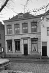 Empire huis onder dwars schilddak en lijstgevel waarin ingang met pilasters