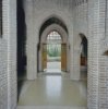 Interieur hal, naar openstaande dubbele tuindeur richting begraafplaats