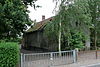 Steenbergen - Welbergsedijk 22 - Voormalige smederij.JPG -  Smederij en woonhuis (186l en 1947). Ambachtelijk-traditionele bouwstijl. Eenlaags woonhuis onder zadeldak met geschulpte overstekken. En een iets lagere aanbouw onder schilddak. Gepleisterde noord- en westgevel. Kleine roederamen en in het woonhuis T-ramen. Gevelsteen: Den eersten steen is gelegd door A C H Korst den 2 april 1861. Goed voorbeeld van een 19de eeuwse plattelands smederij. 