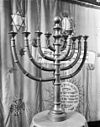 Negenarmige kandelaar (Chanoekia) staande voor de voorhang van de Heilige Arke in de synagoge te Tilburg - Tilburg - 20209241 - RCE -  Synagoge: Negenarmige kandelaar (Chanoekia) staande voor de voorhang van de Heilige Arke in de synagoge te Tilburg 