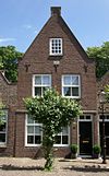 Huis onder zadeldak en met tuitgevel in gele baksteen