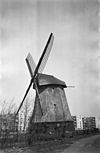 Achtkante rietgedekte molen met flatgebouwen op de achtergrond - Alkmaar - 20006880 - RCE -  Geestmolen: Achtkante rietgedekte molen met flatgebouwen op de achtergrond 
