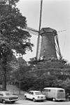 Ronde stenen stellingmolen op bolwerk met geparkeerde auto's op de voorgrond - Alkmaar - 20006892 - RCE -  De Groot: Ronde stenen stellingmolen op bolwerk met geparkeerde auto's op de voorgrond 