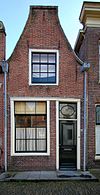 Pand met gemutileerd topgeveltje, boven de pui gepleisterd