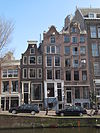 Smal huis met afgeknotte klokgevel thans afgedekt door een lijstje