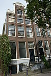 Hoekhuis met halsgevel en een met een versierde verhoging hierbij aansluitende zijgevel