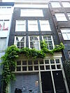 Pand met gevel onder klokvormige top met rollagen