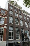 Pand met gevel onder cirkelvormig verhoogde lijst met consoles en rijk gebeeldhouwde attiek