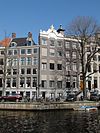 Huis met gevel onder gebeeldhouwde zandstenen verhoogde lijst met opzetstuk