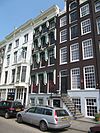 Huis met gevel onder rechte lijst met consoles. Tuinhuis