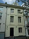 Huis uit het 3e kwart van de 19e eeuw met gepleisterde gevel, voorzien van vensteromlijstingen en een topgevelachtige afsluiting