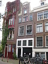 Pand met halsgevel met vleugelstukken van het type met het 'doorboorde-bloem-motief' en lofwerk om een wapenschild in de afdekking