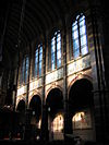 WLM - Minke Wagenaar - Sint Nicolaaskerk 07 - De Sint Nicolaaskerk is de derde Amsterdamse kerk op rij die werd gewijd aan de patroonheilige van de stad. Sint Nicolaas was schutsheilige van de zeevaarders en werd daarom ook vaak als patroonheilige van havensteden gekozen. Het ontwerp van de kerk is van architect A.C. Bleys; de plechtige wijding volgde op 7 februari 1887. Als rooms-katholieke hoofdkerk van Amsterdam moest het gebouw een bijzondere allure uitstralen. Bleys gaf de kerk een neobarok uiterlijk met twee torens en hoge koepel als…