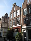 Hoekhuis met latere gevel onder klokvormige top met rollagen