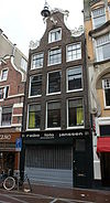 Pand met ingezwenkte halsgevel van zware vormen, gedateerd onder de krullen