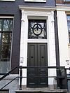 Huis met gevel onder rechte triglyphenlijst met consoles versierde stoep met drie lod