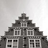 Dubbel hoekhuis met hoge trapgevel, versierd met kleine blokjes