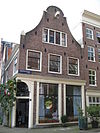 Hoekhuis met voorgevel onder klokvormige top met rollagen