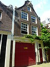 Huis met latere gevel onder klokvormige top met rollagen