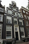 Pand met gevel met grote trappen in late hendrik de keyser-trant waarvan de benedenhelft met deurpartij