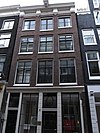 Pand met gevel onder lijst met consoles en triglyfen met houten pui en tabaksrollen als uithangtekens