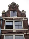 Amsterdam, Prinsengracht 4 detail -  zeer smal huis met gevel, versierd in de trant met grote boogblokken onder klokvormige top