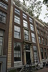 Pand met gevel onder rechte lijst met consoles met gebeeldhouwde ingangspartij en vensterversiering