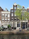 Pand met halsgevel met gedeelde vleugelstukken, volutenafdekking en beeldhouwwerk om de hijsbalk