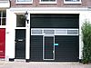 Pand met gevel onder rechte lijst met twee triglyfen en op houten bedrijfspui met geblokte hoekposten