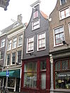 Pand met gevel onder rollagentop met lijst