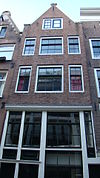Huis met gevel op karakteristieke hoge houten pui en latere punttop