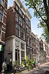 Hoekhuis met pilastergevel onder rechte lijst en overgebouwde zijgevel