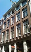 Pand met vijfraamsgevel onder door de vensters doorbroken rechte lijst met twee consoles