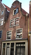 Huis met gevel onder ingezwenkte hals met rollagen