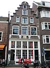 Pand met trapgevel, versierd in de trant met grote boogblokken en met een gevelsteen