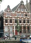 Pand met zesraamsgevel met twee ongelijke, in punttoppen gewijzigde trapgevels, versierd met grote boogblokken