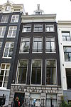 Pand met gevel in traditionele vormen onder lijst met consoles